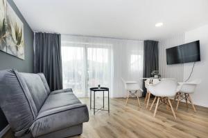 萨拉热窝Royal Grey Apartment的客厅里有一张沙发和一张桌子。