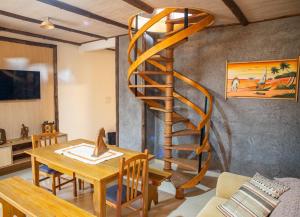 Casa di legno italiana في بينتو جونكالفيس: درج حلزوني خشبي في غرفة معيشة مع طاولة