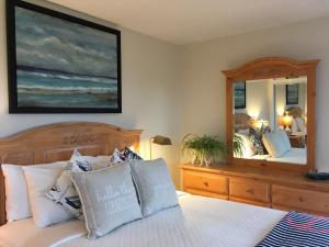 a bedroom with a bed and a large mirror at Belle Maison Auprès De La Mer in Sidney