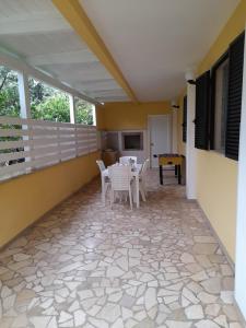 a patio with white chairs and a table at Villa Marta la staccionata in Polignano a Mare