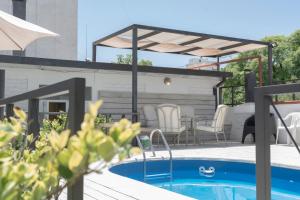 un patio con piscina y pérgola en Hotel San Martín en Mendoza
