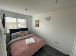 a bedroom with a bed and a clock on the wall at Enjoyable Home in Sunderland