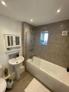 La salle de bains est pourvue d'un lavabo, de toilettes et d'une douche. dans l'établissement Enjoyable Home, à Sunderland