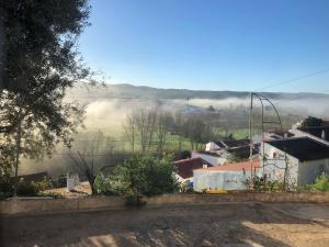 una vista de un pueblo con niebla a lo lejos en Casa Anneli - relaxing under the olive tree, en Aljezur