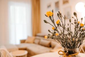um vaso com flores numa mesa numa sala de estar em Baltic Harmony - Easy-Rent Apartments em Pobierowo