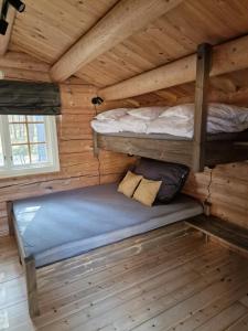 a bedroom with two bunk beds in a log cabin at Weistad in Heidal