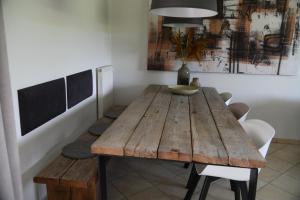 uma sala de jantar com uma mesa de madeira e cadeiras em Boshuis Golfzicht "Wellness, Golf & Nature" em Oosterhout