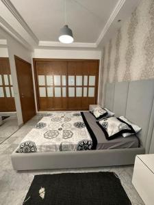 een slaapkamer met een groot bed met kussens erop bij un très beau studio luxueux in Ariana