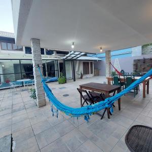 um pátio com uma rede de descanso azul e uma mesa em Pousada Sereia Morena Floripa em Florianópolis