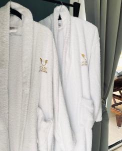 tres toallas blancas colgando en un estante en Ermis Luxury Suites & Apartments, en Amoudara Herakliou