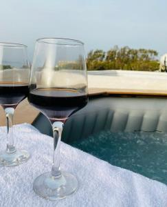 due bicchieri di vino rosso seduti su un tavolo di Ermis Luxury Suites & Apartments ad Amoudara Herakliou