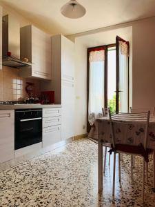 een keuken met een tafel met stoelen en een raam bij Claves Claustri - Appartamento storico con balcone in Sarteano