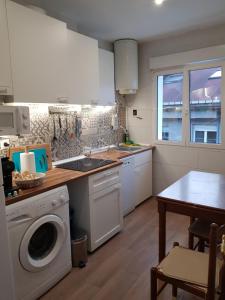 cocina con lavadora y mesa en Vivienda con 3 habitaciones PRÍNCIPE del SILENCIO, en Gijón