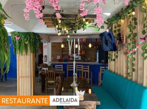 un restaurant avec des fleurs suspendues au plafond dans l'établissement Hotel Pepe Pancho, à San Cristóbal de Las Casas