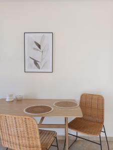 un tavolo da pranzo con due sedie e un quadro di kir-Yiannis stonehouse @Areopoli ad Areópolis