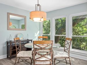 - une salle à manger avec une table, des chaises et un miroir dans l'établissement 2380 Lighthouse Tennis, à Île de Hilton-Head