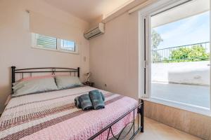 a bedroom with a bed and a large window at George residence Attica Riviera in Kalívia Thorikoú