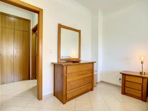 uma casa de banho com uma cómoda em madeira e um espelho em Mare Nostrum em Armação de Pêra