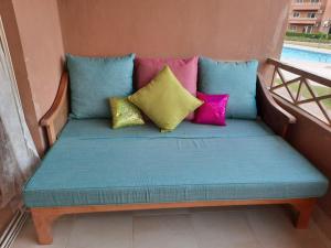 un sofá con almohadas coloridas en el balcón en Deluxe cozy chalet in Malibu Sokhna en Ain Sokhna