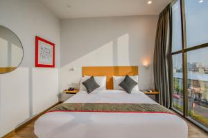 een slaapkamer met een groot bed en een groot raam bij Super Townhouse 596 Hotel KG Estate in Jaipur