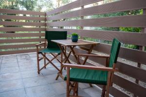 ein Holztisch und Stühle auf einer Terrasse in der Unterkunft Oleoso in Igoumenitsa