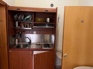 a small kitchen with a sink in a cabinet at Athanasiadis Studios in Nea Vrasna