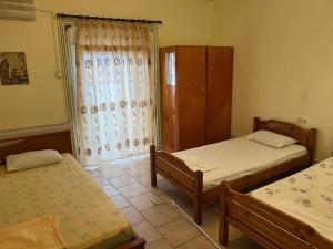 a bedroom with two twin beds and a window at Athanasiadis Studios in Nea Vrasna