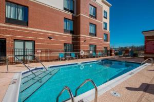 una piscina di fronte a un edificio di TownePlace Suites by Marriott Newnan a Newnan