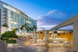 a hotel with tables and chairs in front of a building at Sheraton Puerto Rico Resort & Casino in San Juan