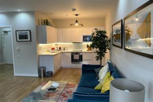 a living room with a blue couch and a kitchen at Fantastic Modern 2 Bedroom Flat in Lambeth in London