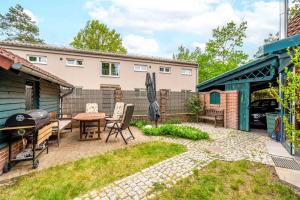 a backyard with a grill and a table and chairs at Familiengeeignete Ferienwohnung in Königs Wusterhausen