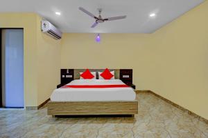 1 dormitorio con 1 cama grande con almohadas rojas en Ab7 Residency Near Miraj Cinemas - Shalini Shivani, en Hyderabad