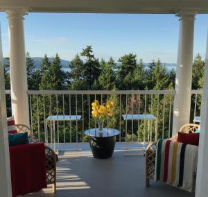 a porch with a vase with yellow flowers on it at Belle Maison Auprès De La Mer in Sidney