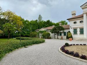 a house with a gravel driveway in front of a yard at VILLA GERLA, un angolo di paradiso vicino Padova e Venezia in Padova