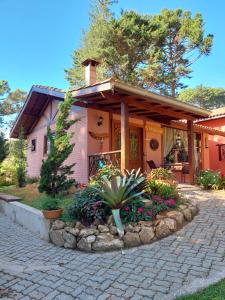 uma casa com uma entrada de tijolos em frente em Pousada Anecuém em Monte Verde