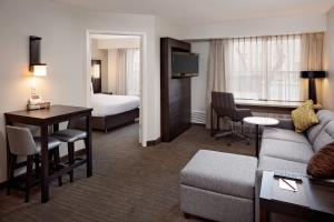 um quarto de hotel com um sofá, uma mesa e uma cama em Residence Inn Arlington em Arlington