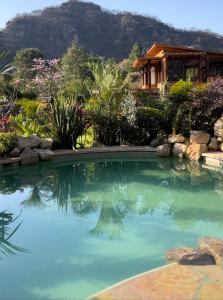 uma piscina com uma casa ao fundo em Casa IxeYolo em Amatlán