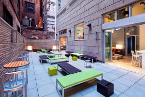 um restaurante com mesas e bancos num edifício em Aloft Manhattan Downtown - Financial District em Nova Iorque