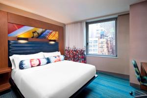 una camera da letto con un grande letto bianco e una finestra di Aloft Manhattan Downtown - Financial District a New York