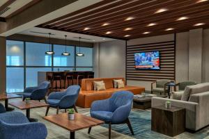 - une salle d'attente avec un canapé, des chaises et une table dans l'établissement Chicago Marriott Schaumburg, à Schaumburg