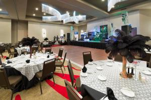 un salón de banquetes con mesas y sillas blancas y palmeras en TownePlace Suites by Marriott Dallas DFW Airport North/Grapevine en Grapevine