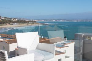 einen weißen Stuhl auf einem Gebäude mit Strand in der Unterkunft Protea Hotel by Marriott Mossel Bay in Mossel Bay