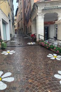 una calle vacía con flores pintadas en el suelo en Daisy House: nice attic in the historical center, en Saló