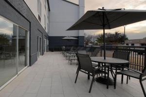 d'une terrasse avec des tables, des chaises et un parasol. dans l'établissement Fairfield by Marriott Inn & Suites Fossil Creek, à Fort Worth