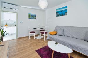 ein Wohnzimmer mit einem Sofa und einem Tisch in der Unterkunft Forr Apartments - Hvar, Croatia in Hvar