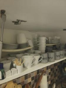une étagère remplie de tasses, d'assiettes et de plats dans l'établissement appartements s 3 avec piscine, à Ariana
