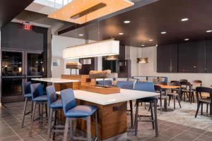 a restaurant with blue chairs and a large table at Courtyard by Marriott Niagara Falls, USA in Niagara Falls