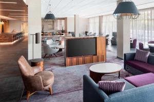 a lobby with a flat screen tv and chairs at Courtyard by Marriott Albany Troy/Waterfront in Troy