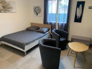sypialnia z łóżkiem, dwoma krzesłami i stołem w obiekcie Grand studio très agréable avec bar, cuisine et terrasse w Cagnes-sur-Mer +26 zdjęć