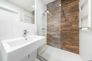 Un baño blanco con lavabo y ducha. en Apartament Grunwaldzka 35, en Olsztyn 10 fotos más